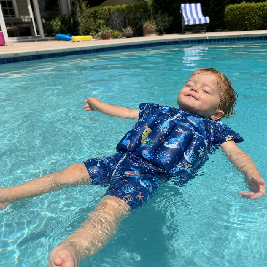 Toddler floating in an Otterly suit